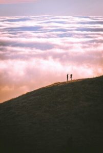 silhouette of a couple on a hill, in the distance